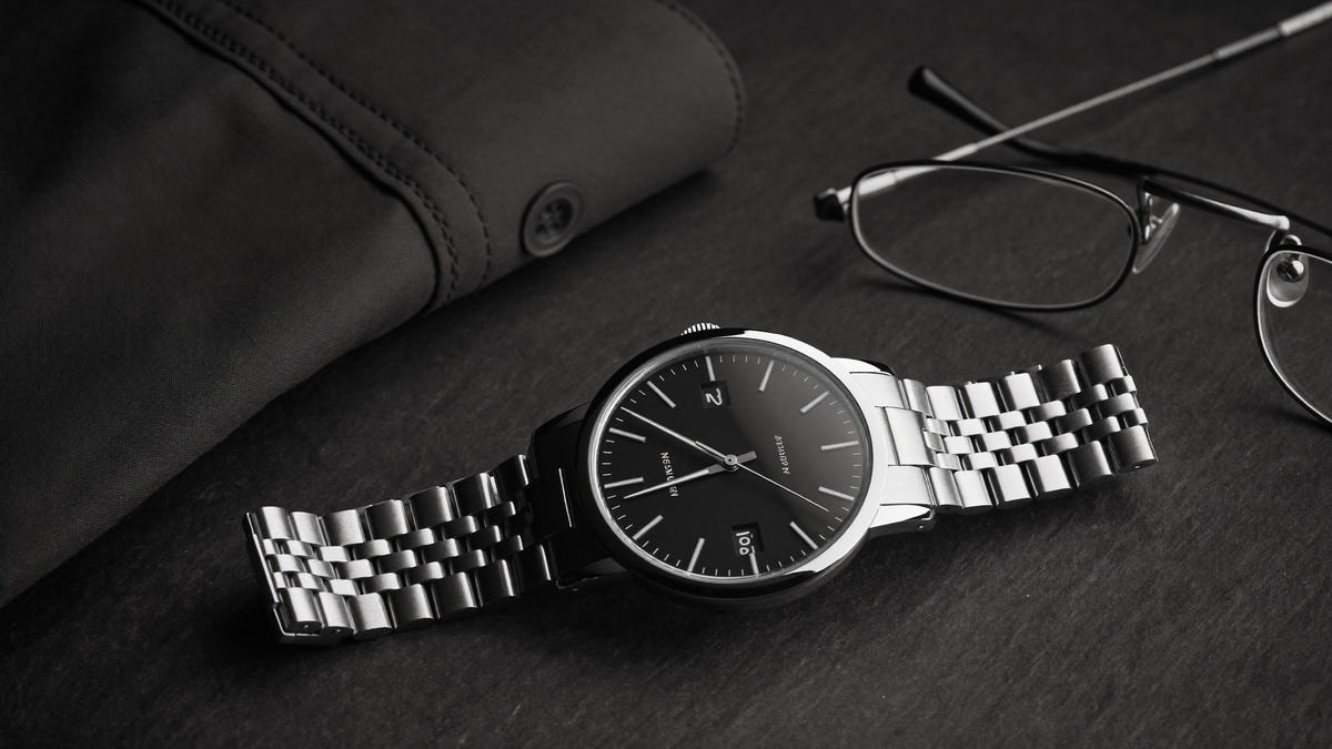 Men's watch buying guide Pakistan, steel watch flat lay with dress shirt and glasses