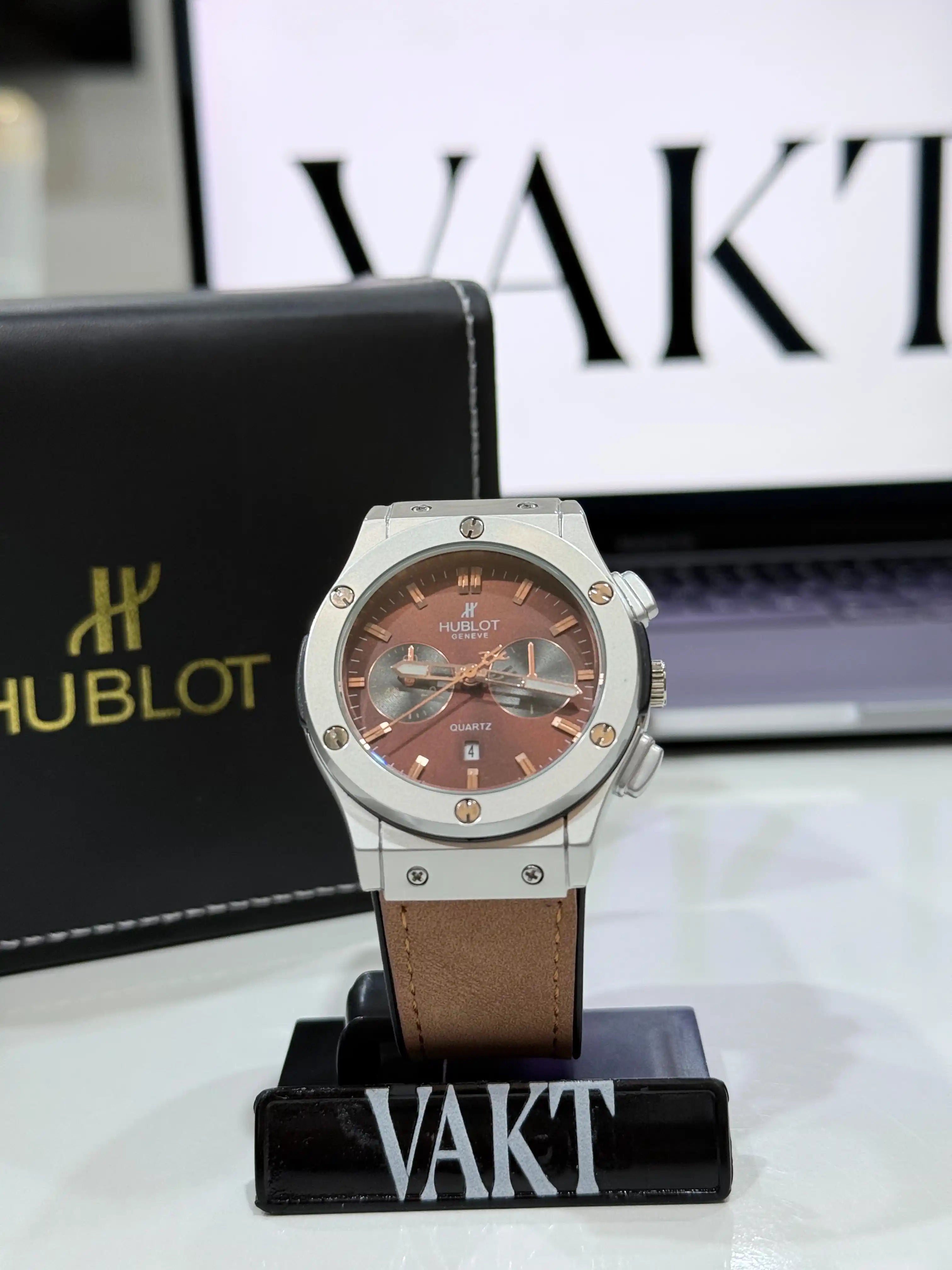 Hublot Geneve Chronograph Watch Brown Leather Strap on a stand with 'Vakt' branding in the background